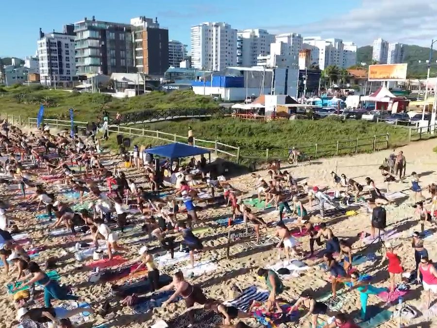Turma de yoga em evento na praia com a Tata Vidal